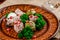 Georgian dish - phali of spinach and meat on a brown plate on a wooden background