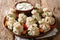 Georgian national dish khinkali dumplings with sour cream, pepper and herbs closeup on a plate. horizontal