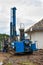 Geothermal drilling for house. Heavy machine with drills next to newly constructed private house