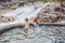 Geothermal spa. Mother and son relaxing in hot spring pool against the background of a waterfall