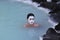 Geothermal spa visitors with silica mud masks relax and refresh at the famous Blue Lagoon