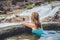 Geothermal spa. Woman relaxing in hot spring pool against the background of a waterfall