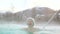 Geothermal spa. Woman relaxing in hot spring pool on Iceland. Girl enjoying bathing in a blue water lagoon Icelandic