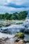 Geothermal terraced pools over mountain stream.