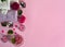 Geranium essential oil, geranium flowers and leaves, pink sea salt, candles and towels on pink background.