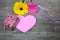Gerberas floewrs with present box and pink paper heart on wood