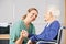 Geriatric nurse holding hands with senior woman