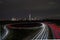 German autobahn with light trains, light trails, direction of Frankfurt and skyline. Night shot, traffic