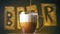 German Beer is pouring into glass on yellow background with inscription: `beer`.