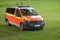 German emergency vehicle or fire engine on a meadow, red yellow marked van for transporting the crew at firefighting operations,