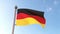 German flag waving isolated with blue sky in background. Close up, Germany, Deutschland, 3d rendering