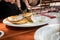 German man eating pork meat Schnitzel Hamburg style with fried eggs, potatoe cucumber salad and bavarian sweet mustard in