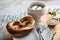 German Munich WeiÃŸwurst white sausage in porcelain pot, Bavarian sweet mustard, butter and pretzel on wooden cutting board during