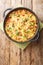 German potato pancake Dibbelabbes with bacon and leek close-up in a frying pan. Vertical top view