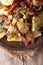 German salad of potatoes with salami and spices closeup vertical