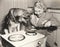 German Shepherd watching woman frying eggs