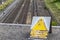 German sign caution high voltage on a bridge above tracks