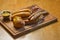 German Thuringer sausage or bratwurst, with baked potatoes and spicy sauce. Served on a rustic wooden board.