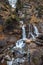 German waterfall - Kuhfluchtwasserfall - near the german alps while autumn. Woman standing in front of the waterfall.