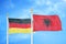 Germany and Albania two flags on flagpoles and blue cloudy sky