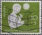 GERMANY - CIRCA 1956: This postage stamp in green shows a girl with a flute and with various symbols on a charity postal stamp for