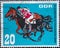 GERMANY, DDR - CIRCA 1967: a postage stamp from Germany, GDR showing a Gallop races. Text: Whole blood meeting of the socialist co