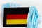 Germany flag covered by surgical protective mask for coronavirus COVID-19 prevention.