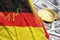 Germany flag and cryptocurrency falling trend with two bitcoins on dollar bills