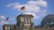 Germany Flags And The Dome of The Reichstag Building in Berlin