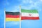 Germany and Iran two flags on flagpoles and blue cloudy sky