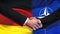 Germany and NATO handshake, international friendship relations, flag background