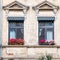 Germany Thuringen, two windows of a vintage building with colorful flower pots