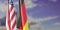 Germany and USA relationship. US America and Italian flags on poles, cloudy sky