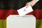 Germany Vote concept. Voter hand holding ballot paper for election vote on polling station