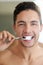 The germs dont stand a chance. Shot of a handsome young man brushing his teeth at home.