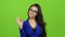 Gesture all okay shows woman in glasses, green screen