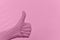 Gesture of a hand thumb up in a rubber glove color pink prism against a raised tinted background with natural folds