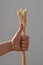 Gesture - thumb up everything will be fine with the hand of a person holding a bunch of wheat ears on a light background.