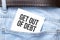 get out of debt words on a white paper stuck out from jeans pocket. Business concept