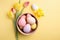 Get ready for Easter with this colorful top view photo of a bowl of Easter eggs, ceramic bunnies