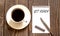 GET READY - white paper with pen and coffee on wooden background