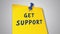 Get support written on yellow sticky note attached with red plastic pin pushpin
