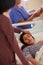 Get well soon.... Shot of a woman touching her friends forehead as she lays in her hospital bed.