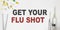 Get Your Flu Shot - text on a white background with pills