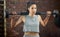 Getting into the best shape. a sporty young woman exercising with a barbell in a gym.