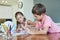 Getting creative together. two adorable little siblings painting together at home.