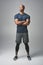 Getting into the fitness zone. Studio shot of an athletic young man standing with his arms crossed against a grey