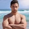 Getting fitter and more confident. Portrait of a handsome young man standing with his arms folded on the beach.