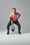 Getting fitter one rep at a time. Studio portrait of an athletic young woman working out with a kettle bell against a