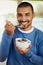 Getting a health boost at breakfast. Portrait of a happy young man enjoying a bowl of muesli at home.